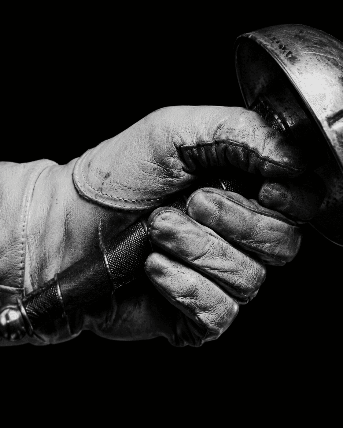 Close-up of a fencing glove gripping a weapon